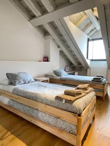 2 Betten in einem Zimmer mit weißen Wänden und Holzböden in der Unterkunft Rio Tío Cocinas in La Granja de San Ildefonso