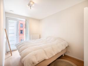 a white bedroom with a large bed and a window at Sable dArgent in Galopen