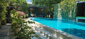 a swimming pool in a yard with flowers and plants at Feyola`s Leaf in Pelena