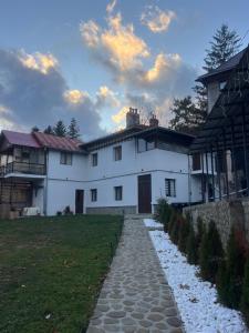 a white house with a stone path in front of it at Casa SEMA in Sinaia