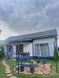 une petite maison avec un banc devant elle dans l'établissement Welcom Verkhovyna, à Verkhovyna