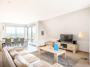 a living room with a couch and a tv at Seawhisper in Galopen