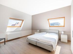 a white bedroom with a bed and two windows at Seawhisper in Galopen