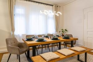 a dining room with a wooden table and chairs at Charaktervolle 122qm Altbau-Ferienwohnung mit Stuck, viel Platz für Familien & Gruppen bis zu 8 Personen, Parkplatz inklusive in Baiersbronn