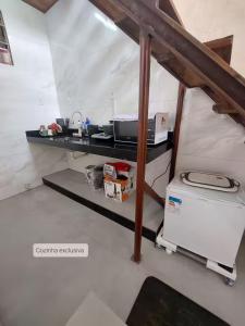 Il comprend une cuisine équipée d'un comptoir avec une cuisinière et un réfrigérateur. dans l'établissement Espaço Tavares Ouro Preto-MG, à Água Boa