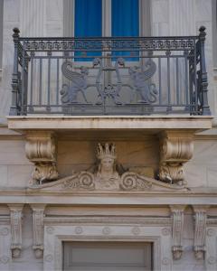 a balcony on top of a building with a statue at Athens 1890 Hotel & Spa in Athens +52 photos