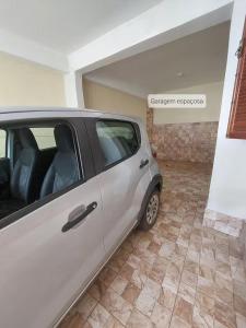 une voiture en argent garée dans un garage dans l'établissement Espaço Tavares Ouro Preto-MG, à Água Boa