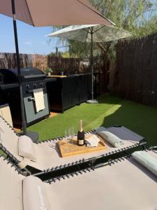 a picnic table with a bottle of wine and an umbrella at The Retreat - Armacao de Pera, Algarve Portugal in Pêra +28 photos