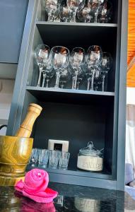 Un armario lleno de copas de vino y un jarrón. en Casa Blanca, en Asunción
