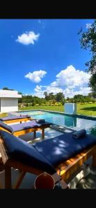 Una gran piscina con sillas con cojines azules. en Casa Blanca, en Asunción