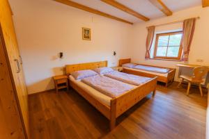 a bedroom with two beds and a table at Untergisserhof in Sesto