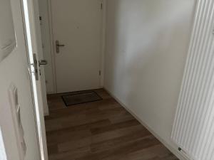 un couloir vide avec une porte et un étage dans l'établissement Ferienwohnung mit Balkon in Steinhagen, à Steinhagen