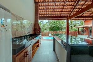 una cucina con lavandino e una piscina di Canto dos Pássaros a Itacaré Altre 51 foto
