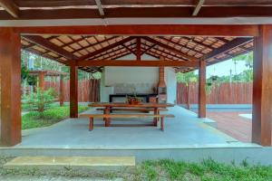 pergolato in legno con tavolo da picnic sotto di Canto dos Pássaros a Itacaré