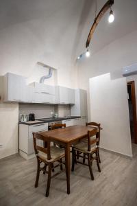 eine Küche mit einem Holztisch und zwei Stühlen in der Unterkunft Zia Lina in Crevari
