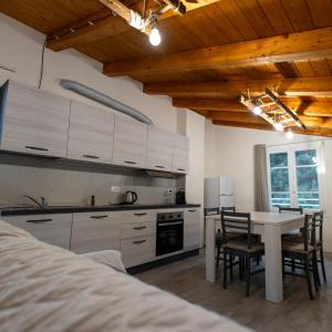 eine Küche mit weißen Schränken und einem Tisch und Stühlen in der Unterkunft Zia Lina in Crevari