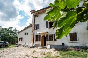 Rovere VeroneseVilla Storica immersa nella Natura Veronese的前面有椅子的白色房子