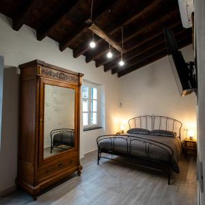 ein Schlafzimmer mit einem Bett, einer Kommode und einem Spiegel in der Unterkunft Zia Lina in Crevari