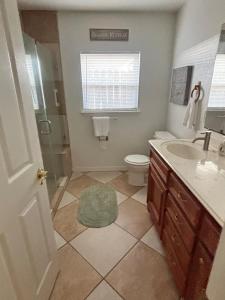 a bathroom with a toilet and a sink and a shower at Paradise Surf House in Galveston