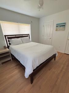 a bedroom with a large bed with white sheets at Paradise Surf House in Galveston