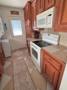 a kitchen with a stove and a microwave at Paradise Surf House in Galveston +7 photos