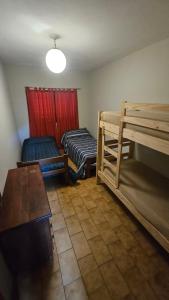 ein Zimmer mit zwei Etagenbetten und einem Tisch in der Unterkunft Arenas Departamentos in Mina Clavero
