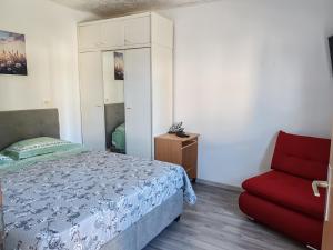 a bedroom with a bed and a red chair at Sorily in Koper