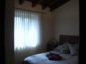 un lit avec deux animaux rembourrés et une fenêtre dans l'établissement Apartamento en Das, à Das