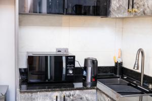 a kitchen counter with a microwave and a sink at Luigi Homes in Kampala +4 photos