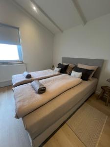 a large bed in a room with a window at Vakantiewoning Hemme Limburg in Simpelveld