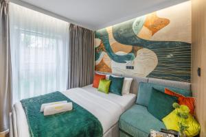 una camera d'albergo con un letto e un divano di Emihouse Rubikon Apartments a Rzeszów Altre 63 foto