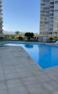 ein großes Schwimmbecken mit blauem Wasser vor einem Gebäude in der Unterkunft Depto Peñuelas in Coquimbo + 6 Fotos