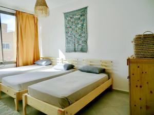 1 dormitorio con 2 camas individuales y una pintura en la pared en Ocean Surf House, en Tamraght Ouzdar 32 fotos más