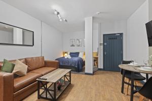 un salon avec un canapé et un lit dans l'établissement Clayton Apartments, à Newcastle upon Tyne