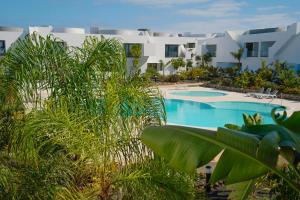 a resort with a swimming pool and palm trees at Sunset House Fuerteventura in Villaverde