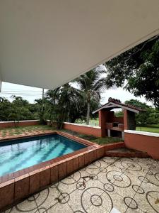 een zwembad met een tafel en een parasol bij Casa Kitesurf - 1 Min a Playa, Pool, BBQ in Chame