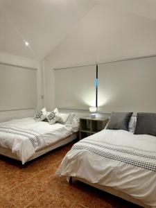 een kamer met twee bedden en een tafel erin bij Casa Kitesurf - 1 Min a Playa, Pool, BBQ in Chame +5 foto's