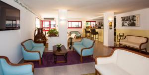 a waiting room with chairs and a couch and a table at Hotel Sofia in Lido di Jesolo