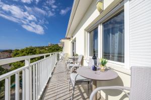 a balcony with tables and chairs and a view of the ocean at Rosemary Apartments in Duće