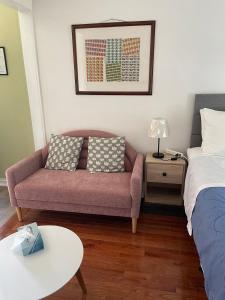 a living room with a couch and a bed at Exquisite 1 Bedroom Suite Charming W Private Entry in Framingham