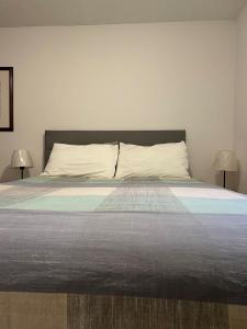 a bedroom with a large bed with two lamps at Exquisite 1 Bedroom Suite Charming W Private Entry in Framingham