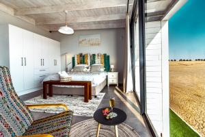 a bedroom with a bed and a table at Dolphin View Beach House in Walvis Bay