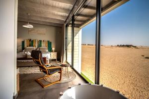 a room with a bedroom and a bed and a tub at Dolphin View Beach House in Walvis Bay