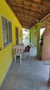 a patio with a table and chairs next to a building at Recanto das Onças in Extrema