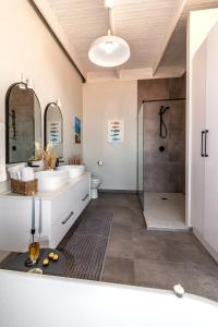 a bathroom with two sinks and a shower at Dolphin View Beach House in Walvis Bay +49 photos