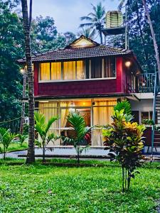 a house with palm trees in front of it at Homestay Rooms Muzhakkunnu Near Kannur International Airport in Iritti