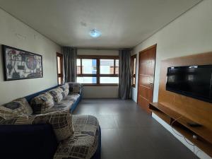 un soggiorno con divani e TV a schermo piatto di Apê Novo Centro de Gramado 02 dorm a Gramado