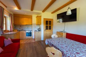 a living room with a red couch and a kitchen at Untergisserhof in Sesto +20 photos