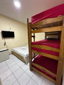 a room with two bunk beds and a flat screen tv at Por do Sol Praia Hotel in Fortaleza