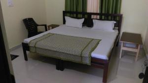 1 dormitorio con 1 cama, mesa y sillas en The Village en Rishīkesh